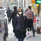 A woman wears a protective mask while walking along the side of a street in the Iranian capital Tehran on February 24, 2020.